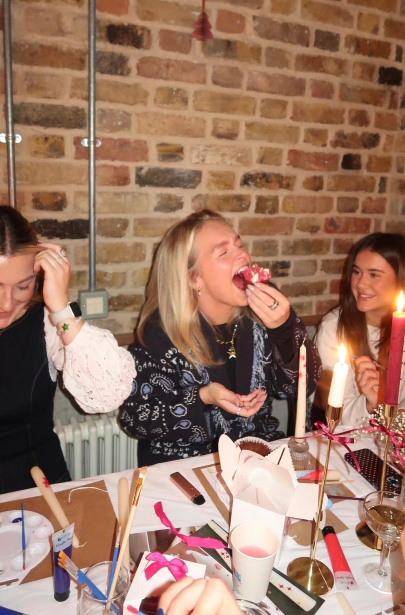 Guest taking a big bite of a cupcake at the workshop table