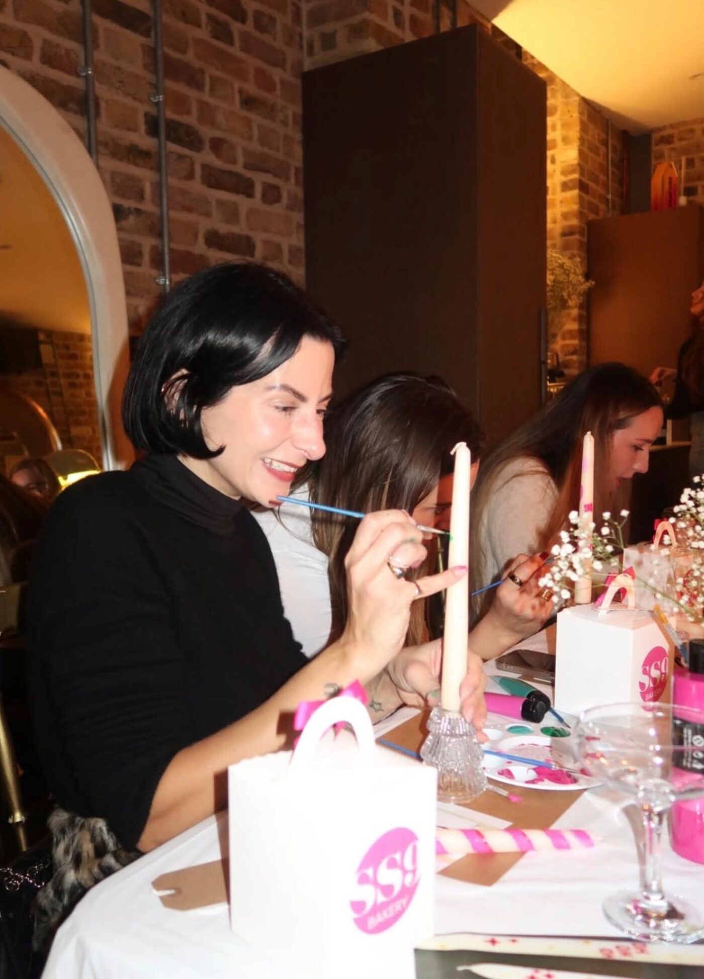 Guest smiling as she paints her candle