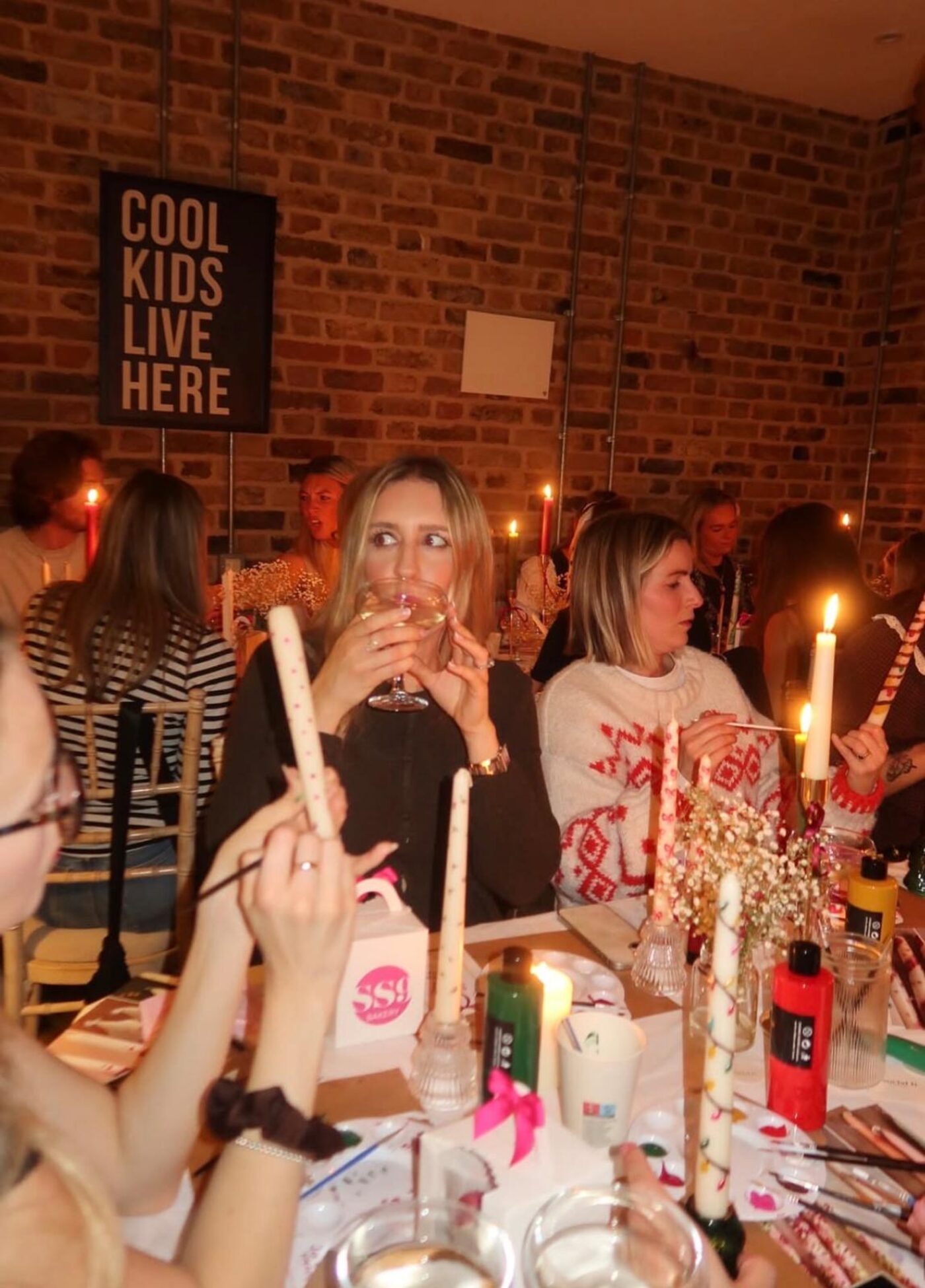 Guests sipping fizz while painting candles