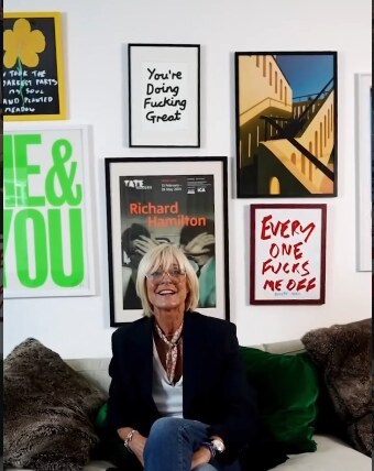 Amanda, filmed in front of a gallery wall of framed prints